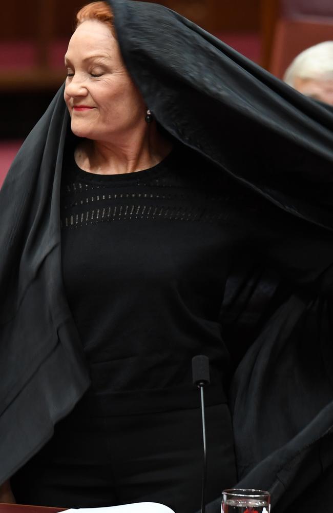 One Nation Senator Pauline Hanson takes off a burqa during Senate Question Time. Picture: AAP