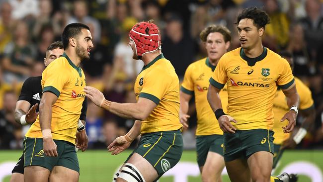 Tom Wright, left, of the Wallabies celebrates with teammates after scoring his team's first try. Picture: Albert Perez/Getty Images