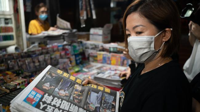 HONG KONG, CHINA - JUNE 18: A woman buys multiple copies of the latest Apple Daily newspaper on June 18, 2021 in Hong Kong, China. Hong Kong's national security police raided the office of Apple Daily, the city's fierce pro-democracy newspaper run by media magnate Jimmy Lai, in an operation involving more than 200 officers. Journalists were barred from their own offices, as Secretary for Security John Lee said the company used "news coverage as a tool" to harm national security, according to local media reports. Police arrested 5 executives including the CEO of Next Digital, which owns Apple Daily, the reports said. (Photo by Anthony Kwan/Getty Images)