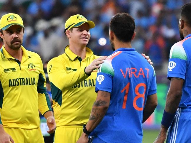 Australia's captain Steve Smith (2L) greets India's Virat Kohli as India's Hardik Pandya (R) watches at the end of the ICC Champions Trophy one-day international (ODI) semi-final cricket match between Australia and India at the Dubai International Stadium in Dubai on March 4, 2025. (Photo by Ryan LIM / AFP)