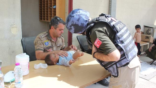 Turkish soldiers take care of a baby as people waiting for evacuation at Hamid Karzai International Airport in Kabul. Picture: Getty Images