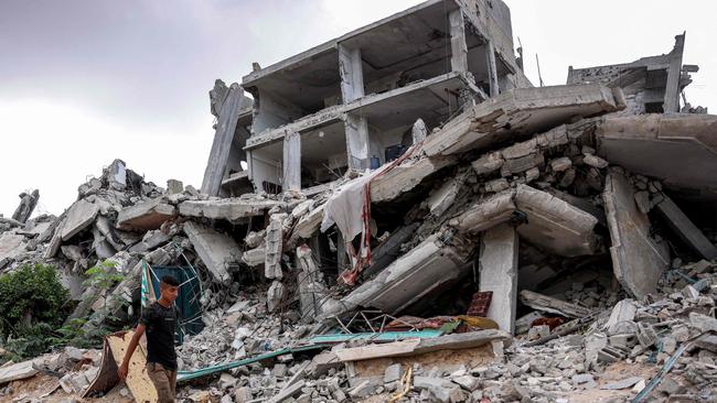 A youth walks past a destroyed building in Khan Younis. Picture: AFP