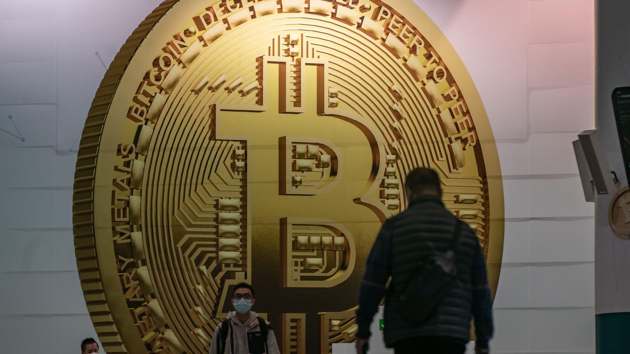 Pedestrians walk past an advertisement displaying a bitcoin cryptocurrency token on February 15, 2022 in Hong Kong, China. Picture: Anthony Kwan/Getty Images