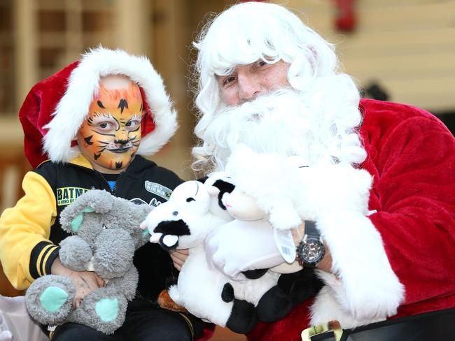 Brody Miller 5, of Bathurst, poses for a photograph with Santa Claus (Nathan Hindmarsh) at Ronald McDonald House which was transformed into a Christmas Wonderland for DoSomething Day 2017. Pic: AAP Image/Justin Sanson