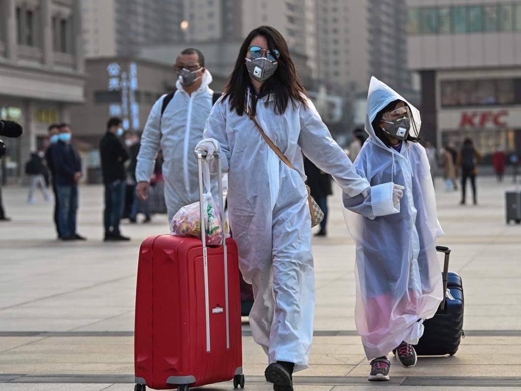 People wearing protective clothing and masks arrive at Hankou Railway Station in Wuhan. Picture: Hector Retamal/AFP