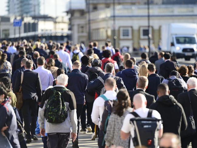 Large crowd of people commuting to work in London, England