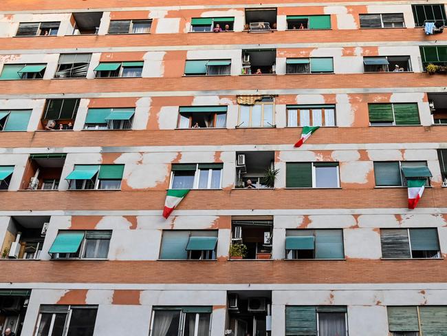 People wave and clap their hands, during a flash mob "Una canzone per l'Italia" (A song for Italy) at Magliana district in Rome. Picture: AFP