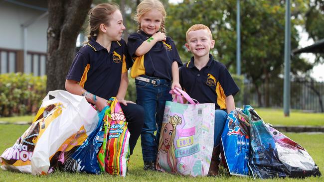 Jasmine Cook, 9, Emalee Cape, 4, and Liam Cape, 7, sample the Showbags for the 2021 Sydney Royal Easter Show, at The Royal Stables, Sydney Showground, today. Picture: Justin Lloyd.