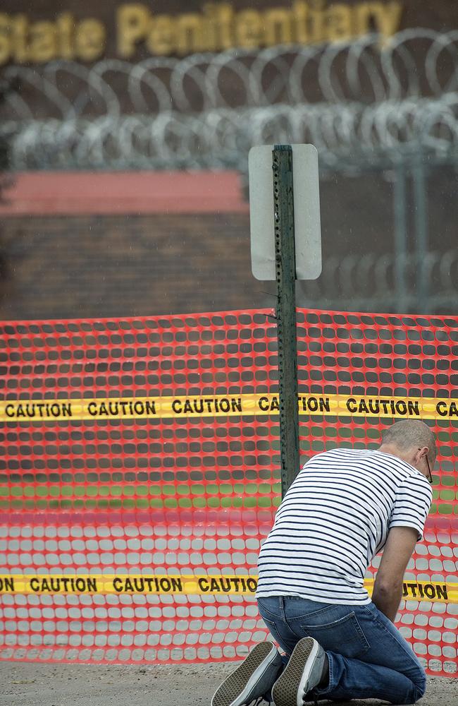 A man kneels outside the Nebraska State Penitentiary as Carey Dean Moore is executed via lethal injection. Picture: Eric Gregory