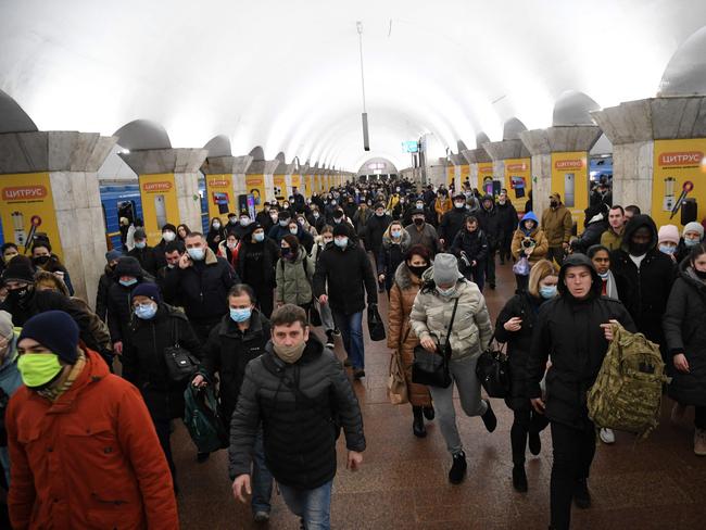 People carrying bags and suitcases escape Kyiv via the metro as explosions ring out across the city. Picture: AFP