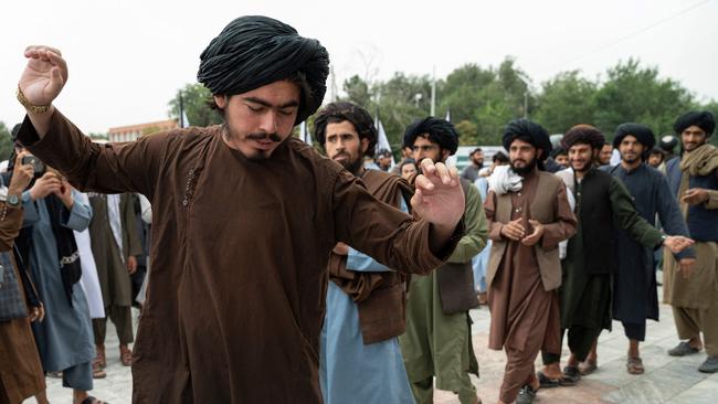 Taliban fighters dance as they celebrate their victory at the Ahmad Shah Massoud Square in Kabul on August 15.