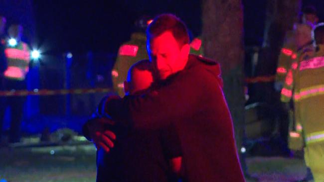 Two men embrace at the crash site. Picture: TNV