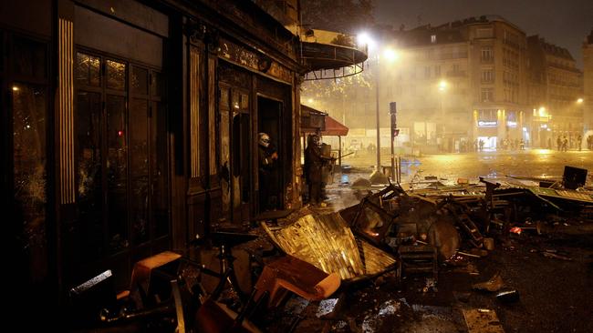 Riot police stand amid damage outside La Belle Armee restaurant on the Champs-Elysees, which was ransacked during a protest by yellow vests against rising oil prices and living costs. Yellow vest participants say the protest was infiltrated by professional rioters, who ‘came to fight’. Picture: AFP