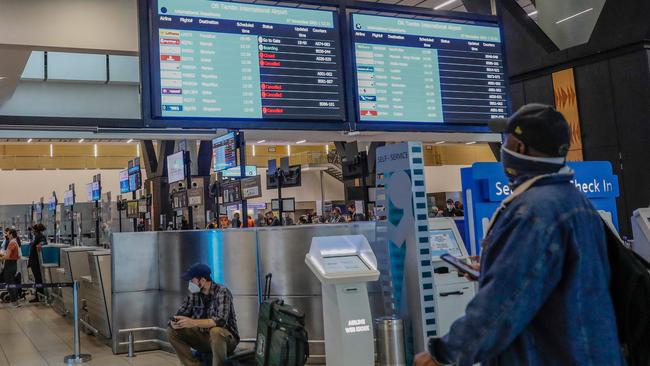 A traveller looks at cancelled flights at OR Tambo International Airport in Johannesburg after the new Omicron variant was discovered. Picture: AFP