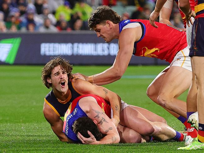 Lachie Neale holds his head after the tackle from James Peatling. (Photo by Sarah Reed/AFL Photos via Getty Images)
