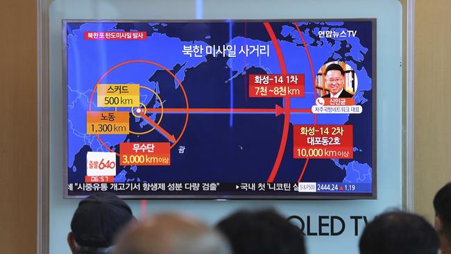 People watch a TV news program reporting North Korea's missile launch at Seoul Railway Station.