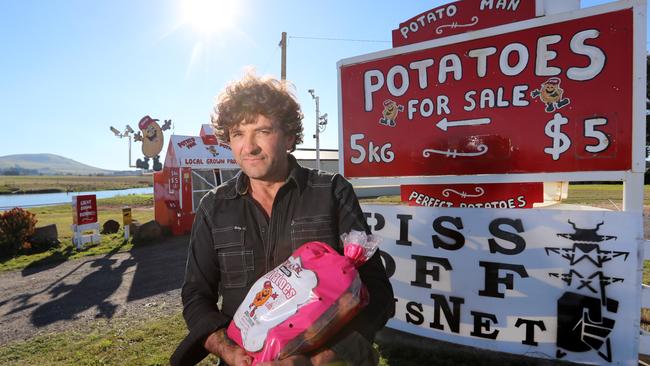 Potato farmer Anthony Fraser in front of a protest sign against AusNet. Picture: Alex Coppel