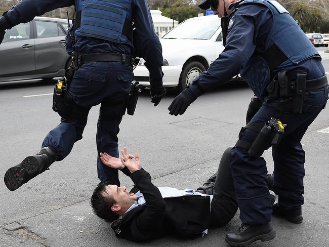 Police tackle a “No Room for Racism” protester. Picture: Jake Nowakowski