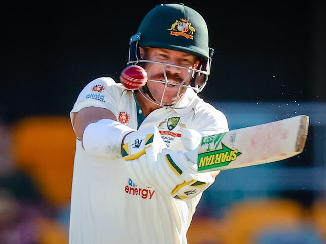 TOPSHOT - Australia's David Warner plays a shot during day three of the fourth cricket Test match between Australia and India at the Gabba in Brisbane on January 17, 2021. (Photo by Patrick HAMILTON / AFP) / -- IMAGE RESTRICTED TO EDITORIAL USE - STRICTLY NO COMMERCIAL USE --