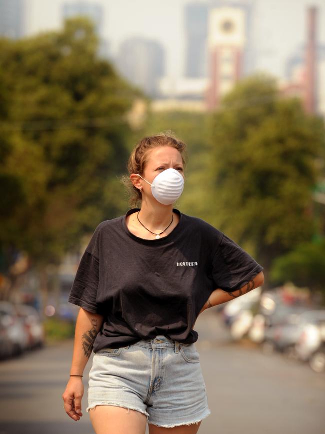 A woman shields herself from the thickening haze. Picture: Andrew Henshaw