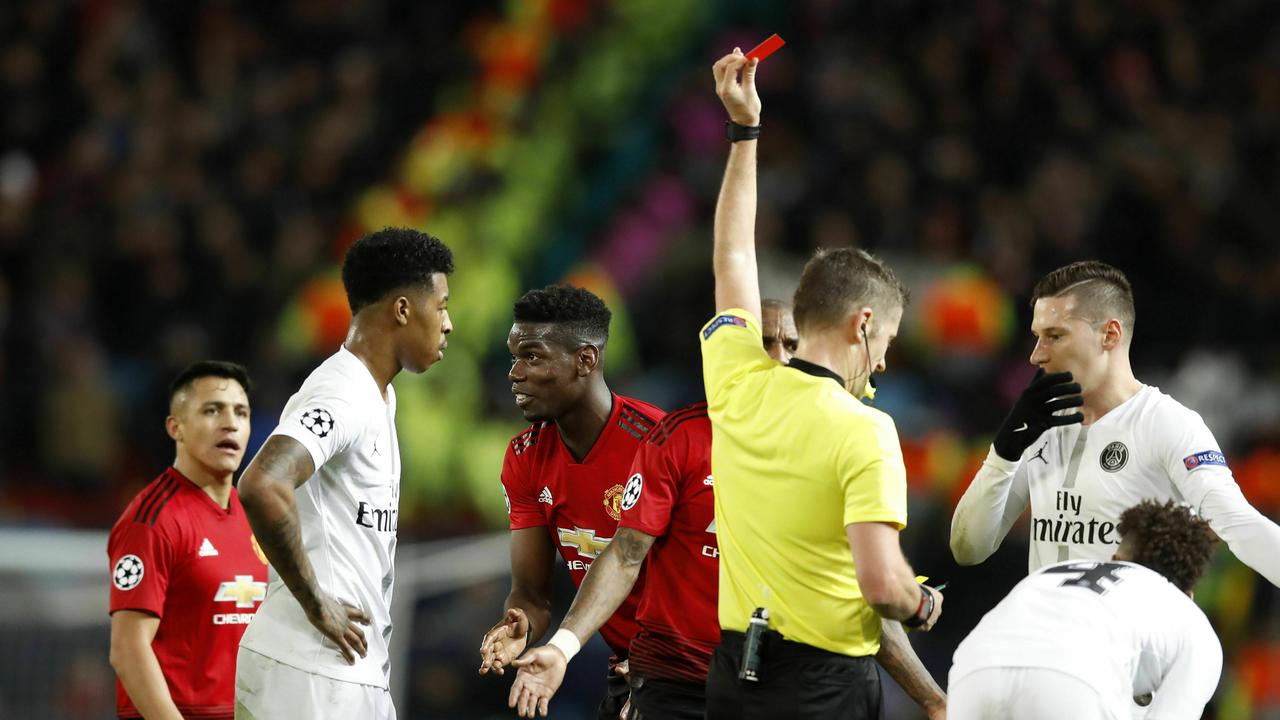 Manchester United's Paul Pogba, center, is shown a red card