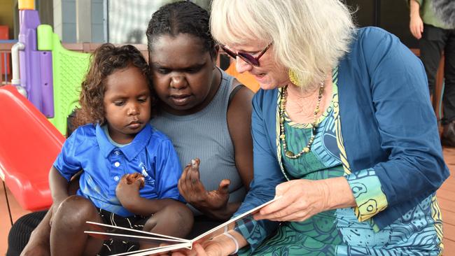 Gunbalanya School's first Families as First Teachers Educator Nuala Scannell works through conversational reading exercises with a parent and child as part of the FAFT program. Picture: Sierra Haigh