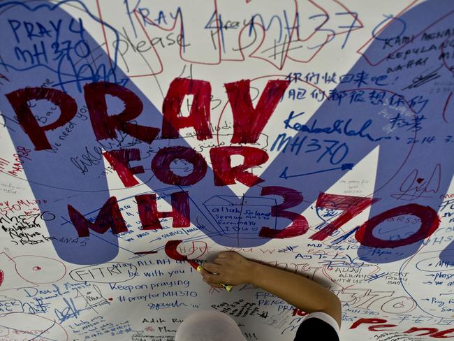 A Malaysia Airlines employee writes a message of support in Sepang on March 14, 2014. Picture: AFP/Manan Vatsyayana