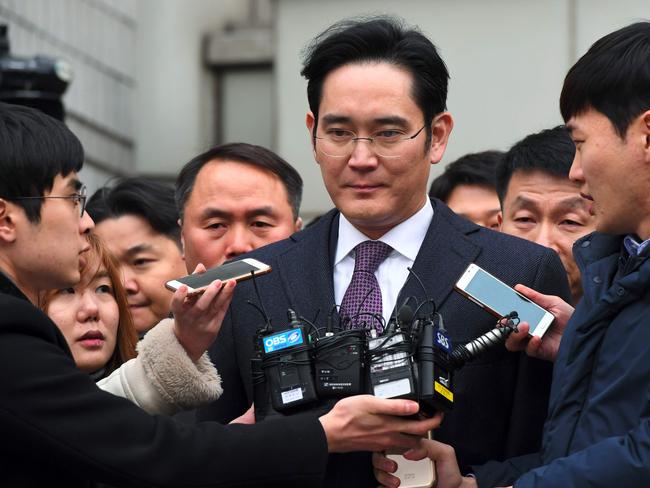Samsung Group's heir-apparent Lee Jae-Yong (C) leaves for a waiting facility after attending a court hearing on whether he will be issued with an arrest warrant at the Seoul Central District Court in Seoul on January 18, 2017. The heir apparent to the Samsung business empire appeared at a South Korean court on January 18 as a judge began deliberating whether to formally arrest him over his alleged role in a snowballing corruption scandal engulfing President Park Geun-Hye. / AFP PHOTO / JUNG Yeon-Je