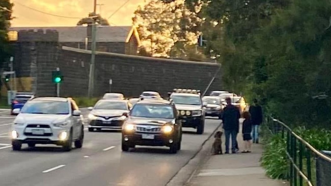 A family walks next to Murray Rd showing how close traffic gets to the footpath.