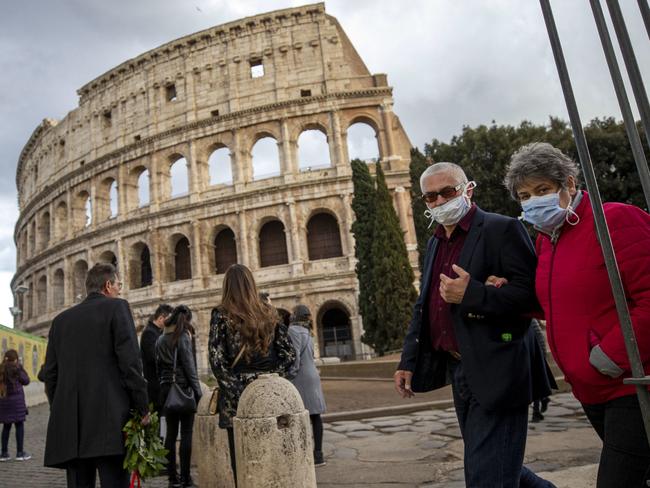 Tourists wear face masks as they walk close to the Colosseum in Rome, Italy. Picture: EPA