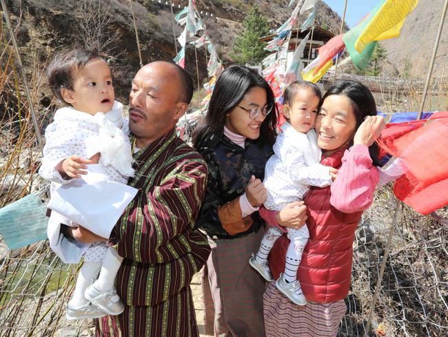 Father Sonam Ushering holds Dawa as her older sister, Ugyen Choden, and mum Bhumchu Zangmo hold twin sister Nima at the Tangchog Temple after returning home. Picture: Alex Coppel