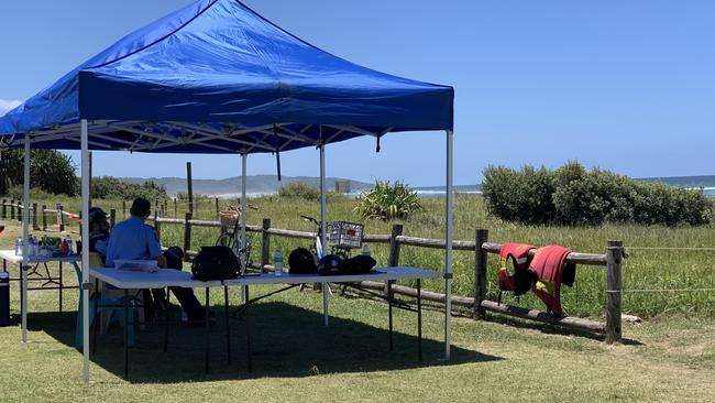 Police take cover from the sun during a search at Lennox Head for Alane Etoundi on Saturday. Picture: Liana Walker