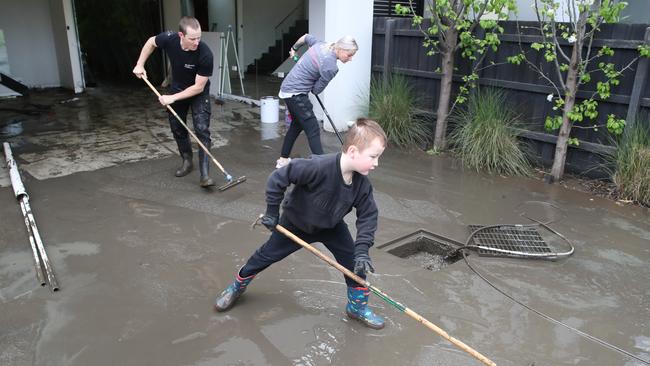 Jack, 8, and his mum Nikki help clean up the home of his uncle, Leigh Jacobs. Picture: David Crosling