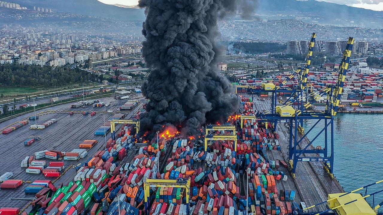 Smoke rising from burning containers at the harbour of Iskenderun in Hatay, a day after a 7.8-magnitude earthquake struck the country's southeast, on February 7. (Photo by Handout / DHA (Demiroren News Agency) / AFP)