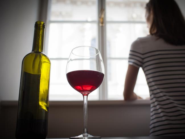 Woman drinking wine alone in the dark room