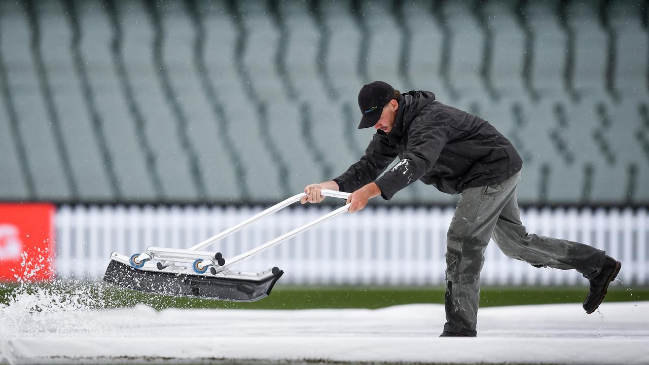 Adelaide Oval ground staff clearing water off the covers Picture: Mark Brake/Getty Images