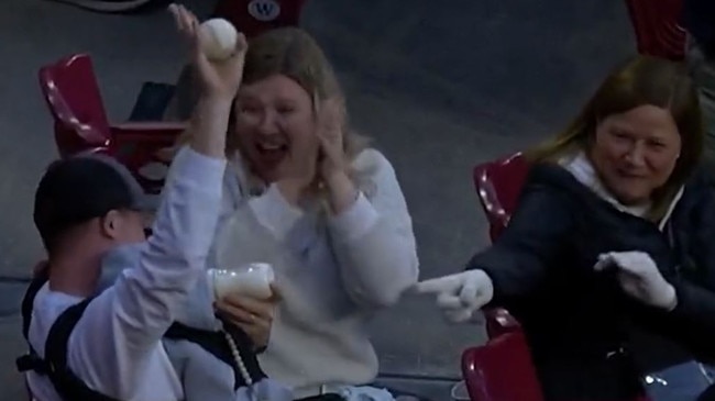 This Cincinnati Reds fan became an overnight cult hero after he managed to catch a foul ball while bottle-feeding his newborn son at Cincinnati’s Great American Ball Park on Wednesday AEST.