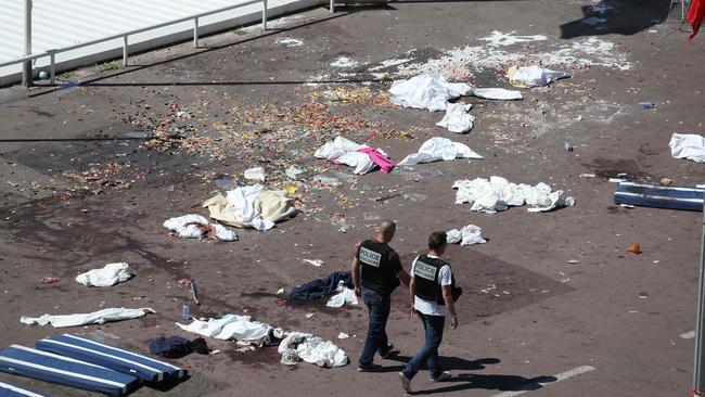 Policemen walk on the site where a truck drove into a crowd watching a fireworks display on the Promenade des Anglais seafront in the French Riviera town of Nice on July 15, 2016. Picture: AFP / Valery Hache