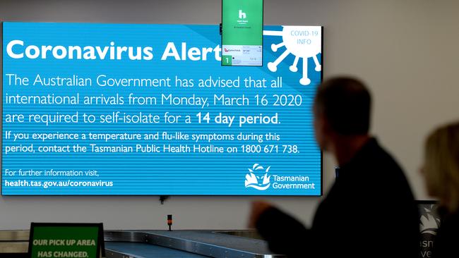 HOBART, AUSTRALIA - MARCH 19: Passengers reading information supplied at Hobart airport on March 19, 2020 in Hobart, Australia. The Tasmanian premier Peter Gutwein has announced all interstate travellers will be required to quarantine for 14 days. The measures are the toughest to be imposed in Australia, and will come into effect from Friday 20 March. There are now 596 confirmed cases of COVID-19 In Australia, while there have been six confirmed deaths, five in NSW and one in Western Australia. (Photo by Steve Bell/Getty Images)