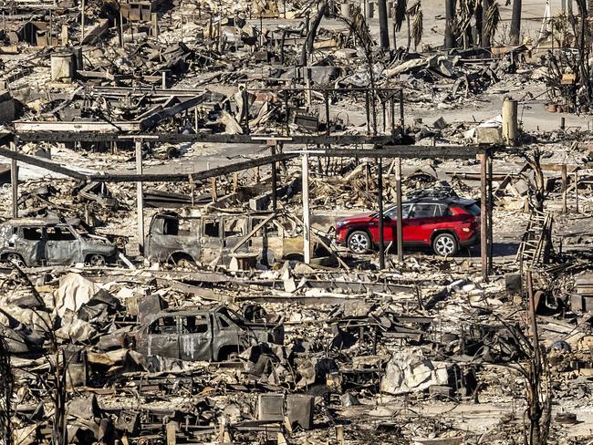 A car drives past homes and vehicles destroyed by the Palisades Fire. Picture: AP Photo