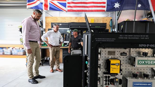 Labor candidate for Leichhardt Matt Smith and Defence Minister Richard Marles inspect an Oxygen Jam machine manufactured by J3Seven with the company's instrument technician Sean Reason. Picture: Brendan Radke