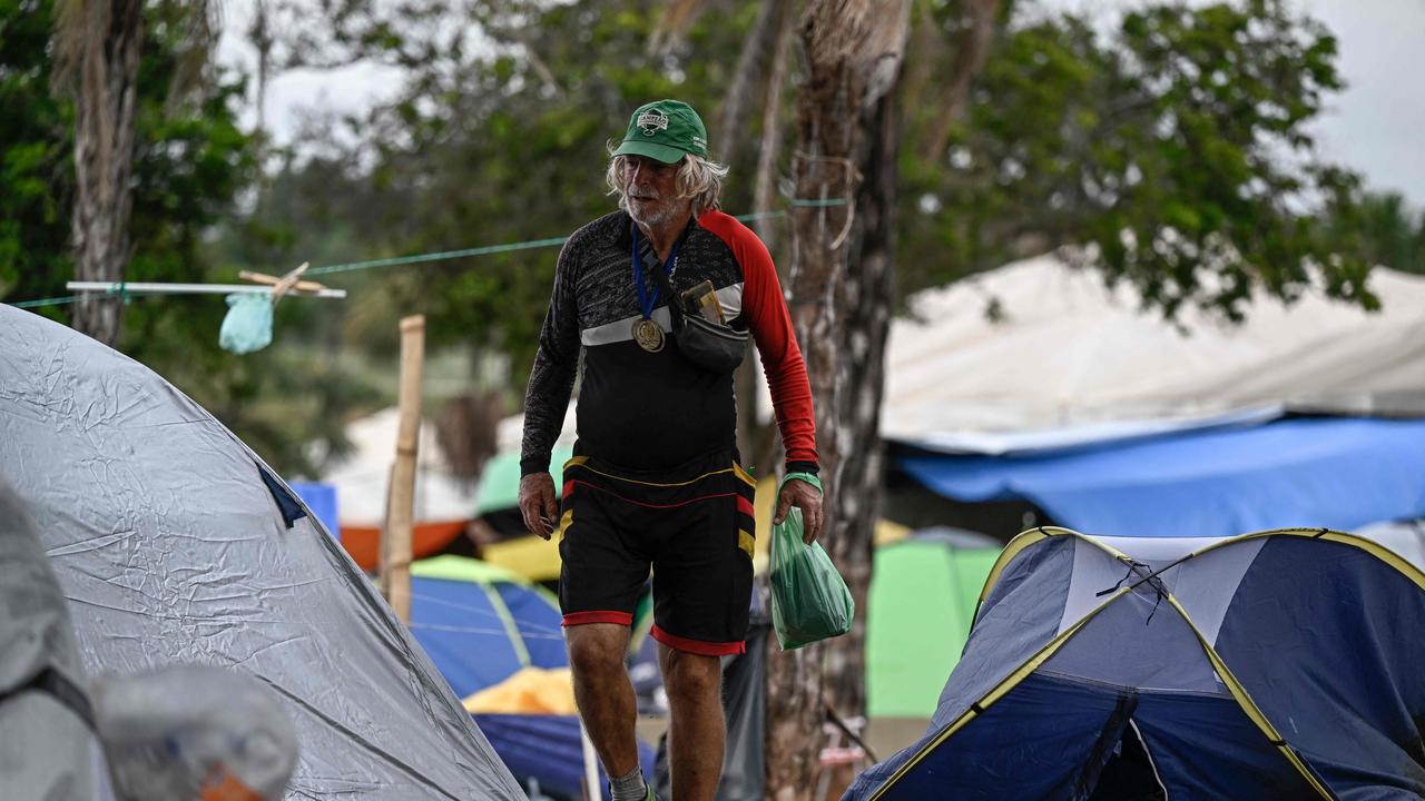 A supporter of Brazil's far-right ex-president Jair Bolsonaro walks between tents as soldiers dismantle the camp. Picture: AFP