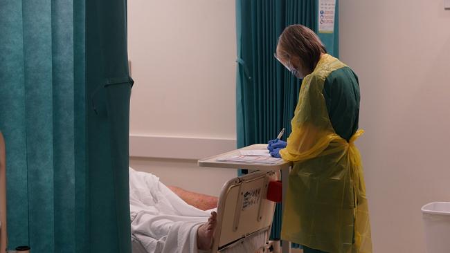 Registered nurse Belinda Watson treats a patient in the emergency department’s COVID-19 quarantine zone for new arrivals. Picture: Mark Isaacs