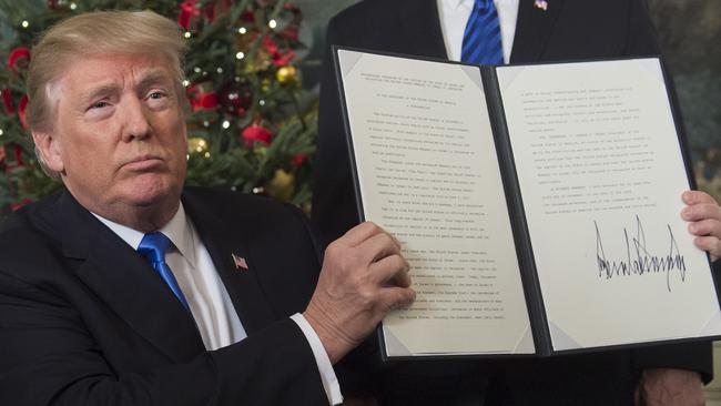 Donald Trump holds up a signed memorandum after he delivered a statement on Jerusalem from the Diplomatic Reception Room of the White House. Picture: AFP.