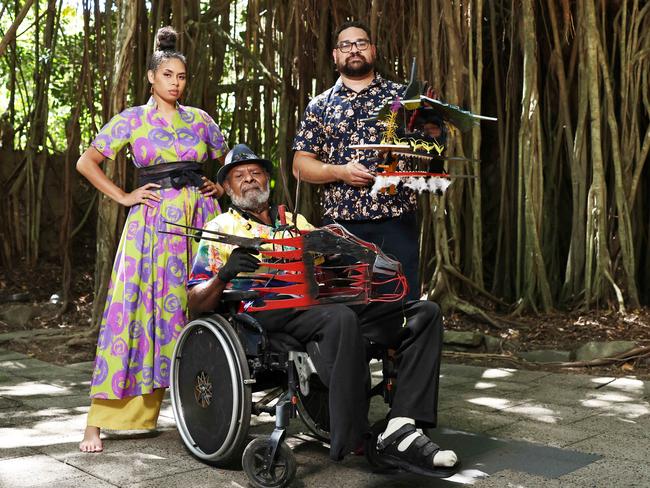 The Cairns Indigenous Art Fair will return to the Tanks Arts Centre this year, where the event was officially launched on Friday. Gillyba Ambrum models a bespoke dress by designer Lynelle Flinders, while  Erub Island artist Dr Ken Thaiday Senior shows CIAF artistic director Theo Ropeyarn has world renowned Torres Strait Island headdresses. Picture: Brendan Radke