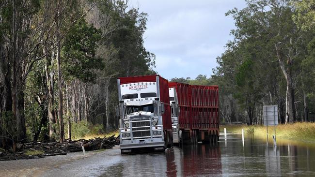 A pair of trucks are seen stuck on a flooded road near the overflowing Richmond river in the outskirts of Lismore, NSW on March 1. Picture: Saeed Khan