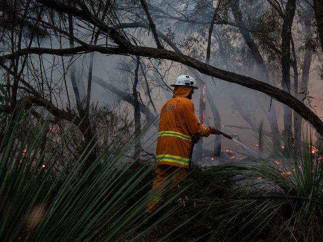 Kangaroo Island fire. CFS volunteers fight the fire front in light rain on Roland Hill Hwy. Picture: Brad Fleet