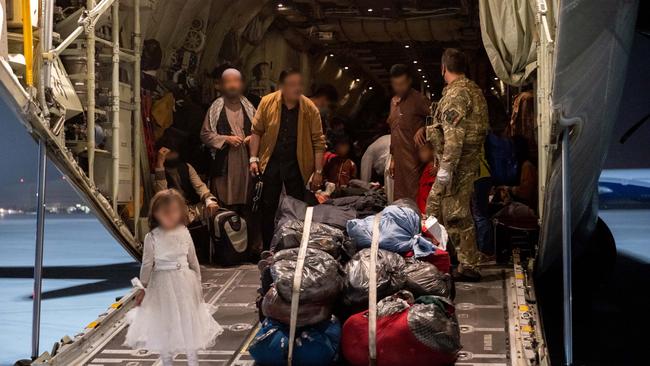 Evacuees from Afghanistan prepare to disembark a Royal Air Force C-130 Hercules at Australia’s main operating base in the Middle East.