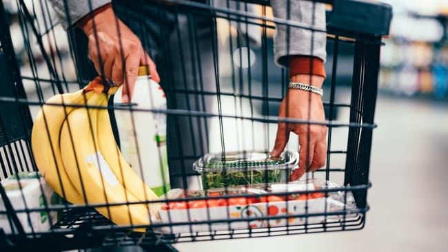 Close up of an unrecognizable man putting groceries into a shopping cart in the supermarket.  Picture: istock