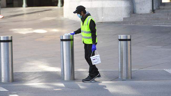 A worker cleans security bollards outside Flinders Street station. Picture: AFP